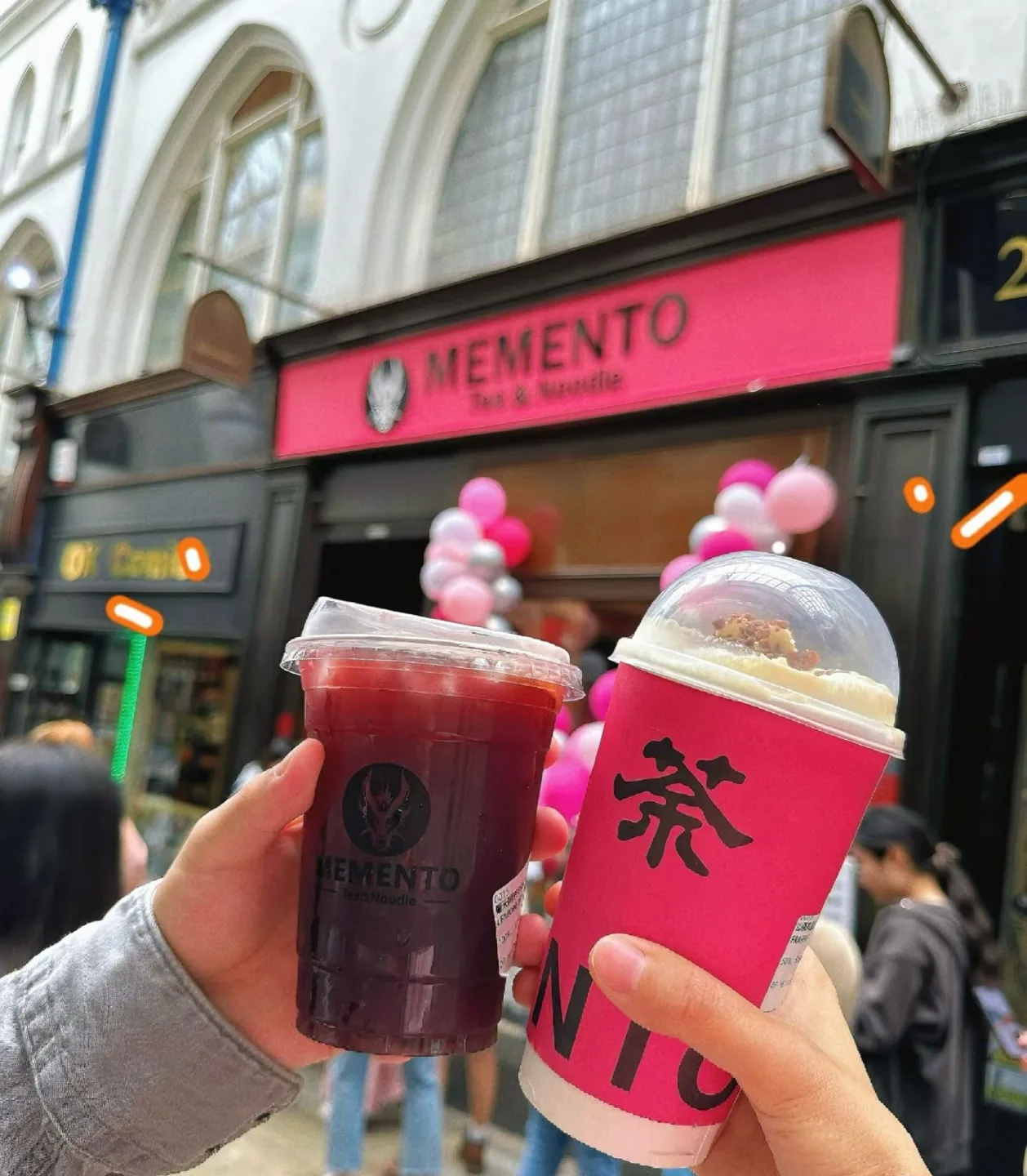 Friends holding Memento tea in front of our shop